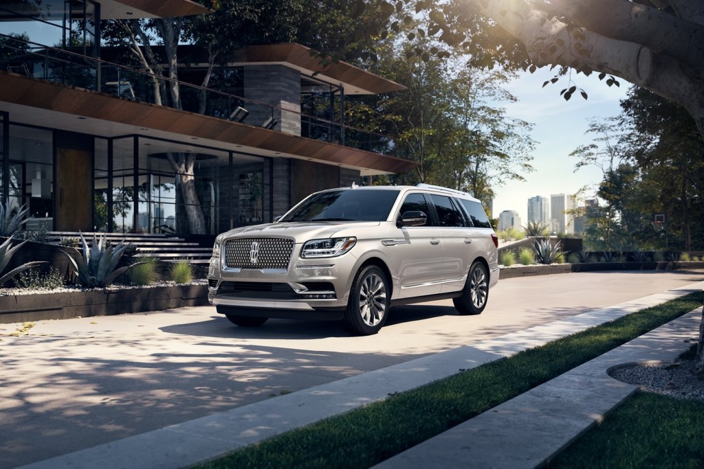 Silver 2021 Lincoln Navigator parked next to a large house
