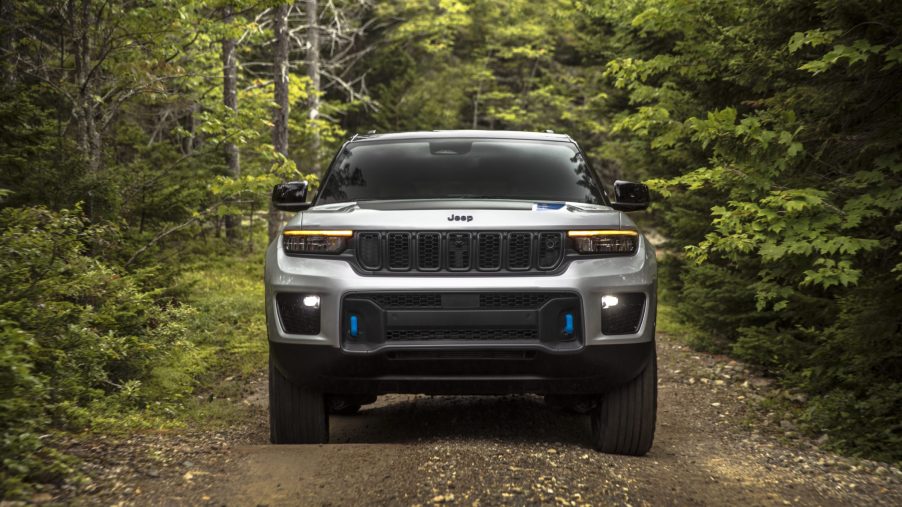 Silver 2022 Jeep Grand Cherokee 4xe driving through a forest