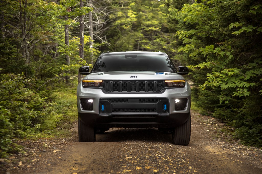 Silver 2022 Jeep Grand Cherokee 4xe driving through a forest