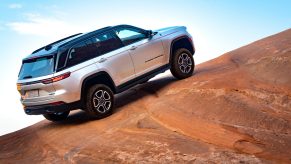 Silver 2022 Jeep Grand Cherokee 4xe driving up a hill