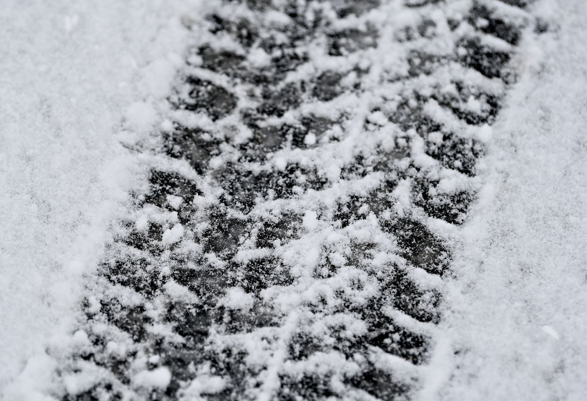 A snow tire print in the snow.