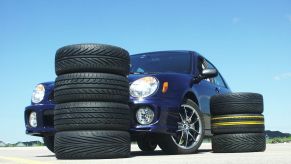 A 2003 Subaru Impreza TS2.5 parked by stacks of tires