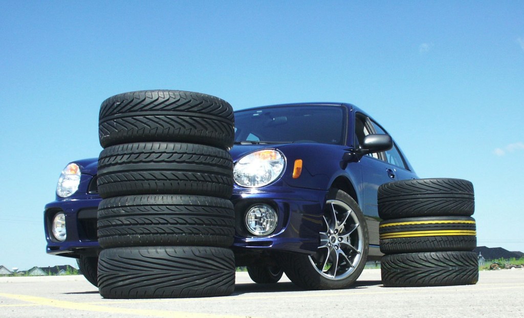 A 2003 Subaru Impreza TS2.5 parked by stacks of tires