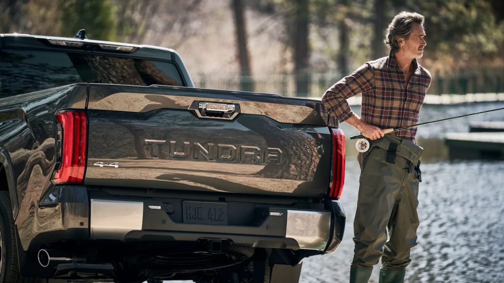 This is a promo photo of the 2022 Toyota Tundra hybrid shown in gray with a fly fisherman