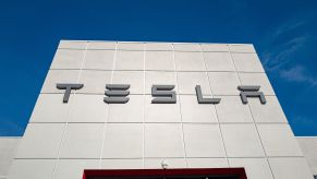 White Tesla building with Tesla written in grey against a blue sky.