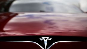 Tesla logo, creator of autopilot, on a red car.