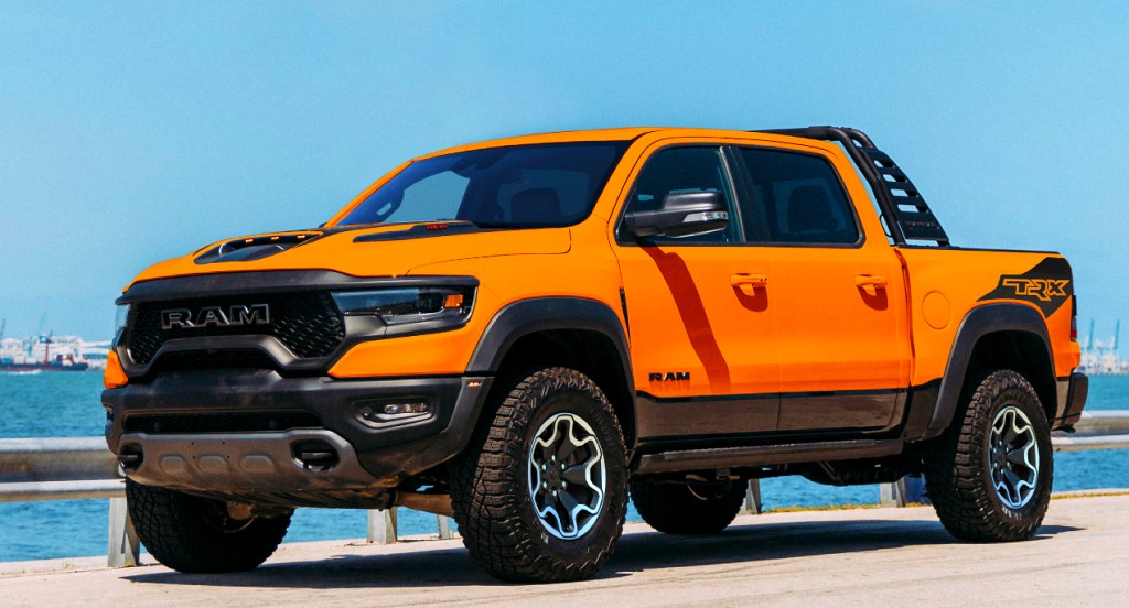 An orange 2022 Ram 1500 TRX Ignition Edition is parked with a body of water in the background.