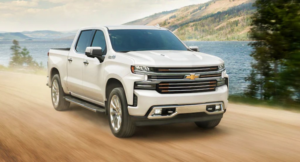 A white 2021 Chevy Silverado on a dirt road. Truck prices are way up right now.