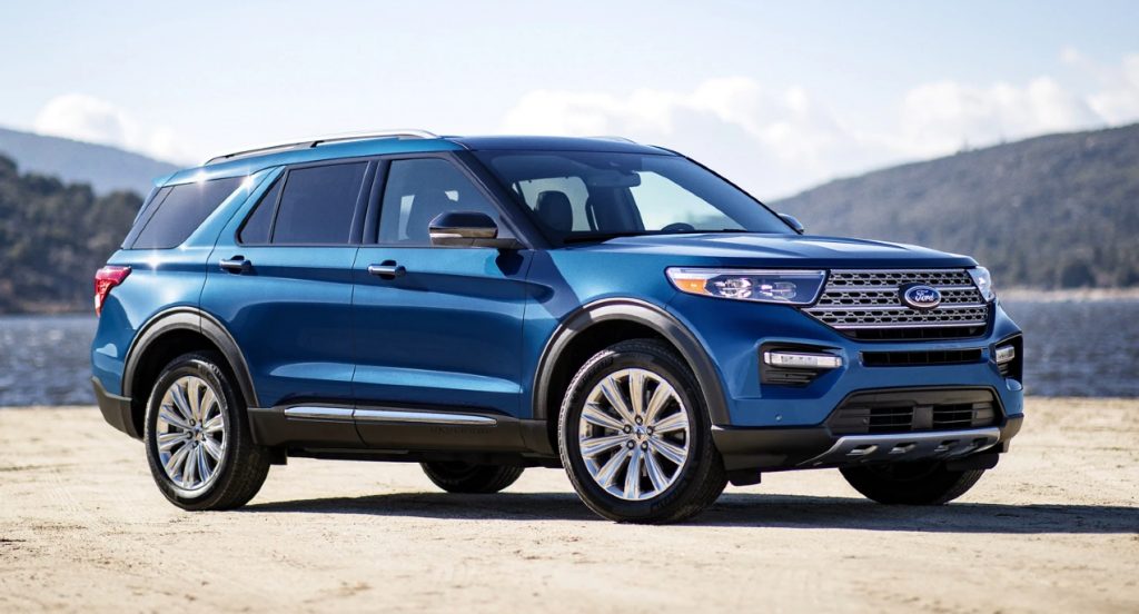 A blue Ford Explorer parked near mountains and water