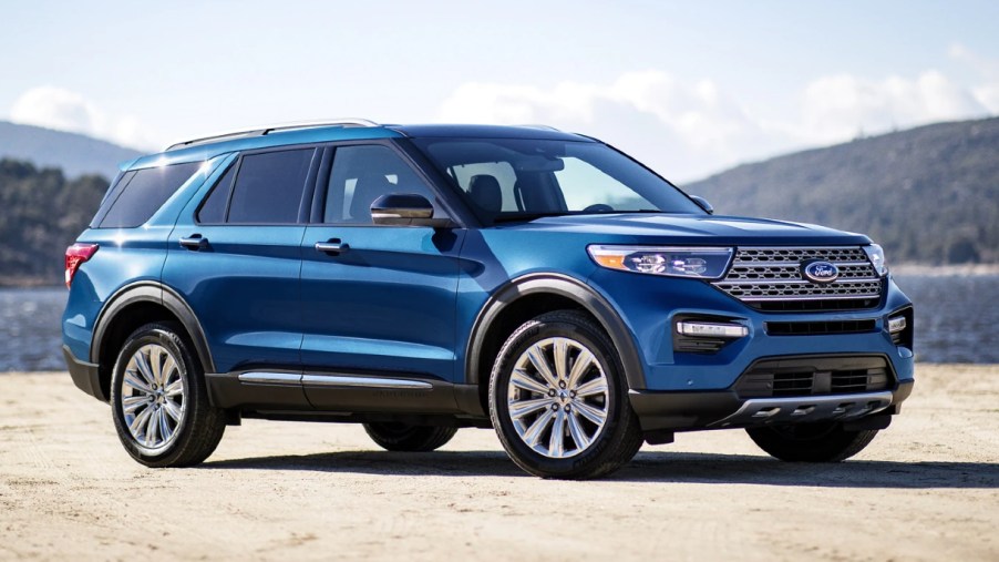 A blue Ford Explorer parked near mountains and water