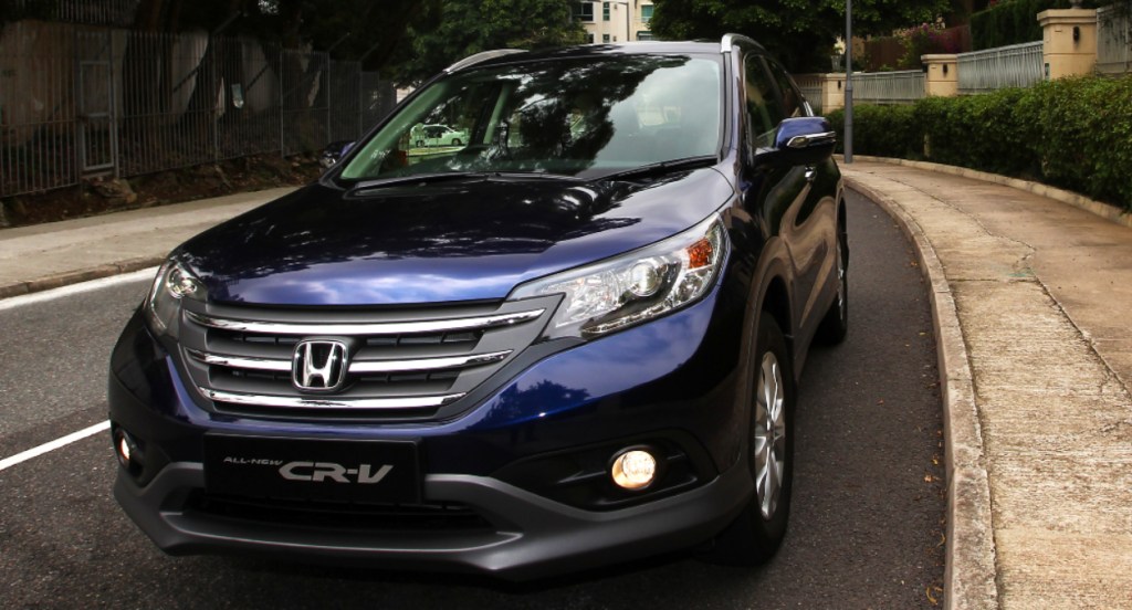 A navy blue Honda CR-V SUV is parked on a street. 
