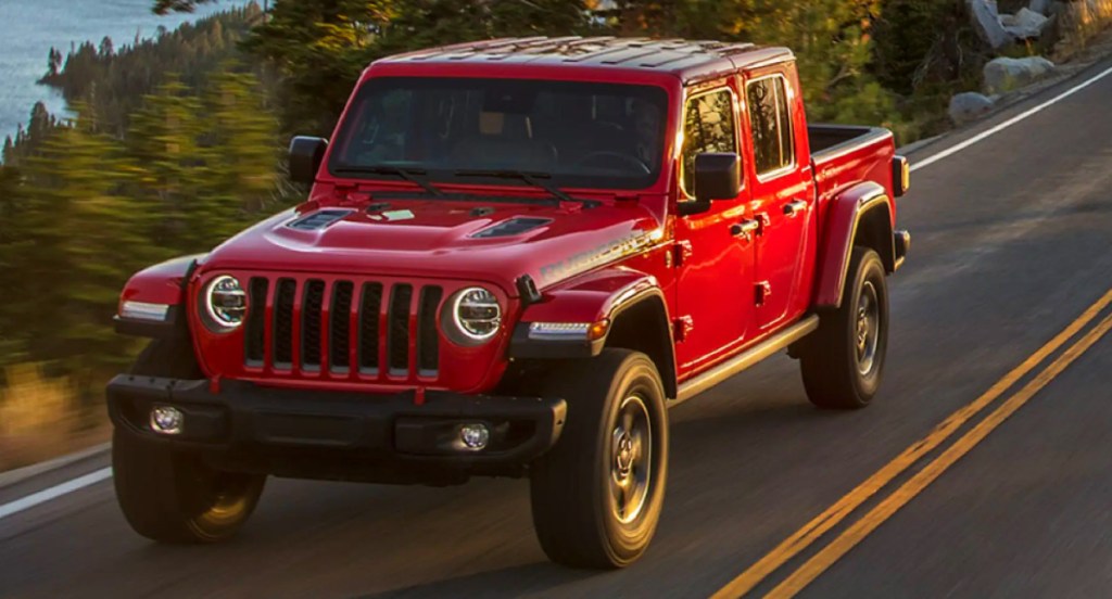 A red 2021 Jeep Gladiator pickup truck is driving on a highway. 