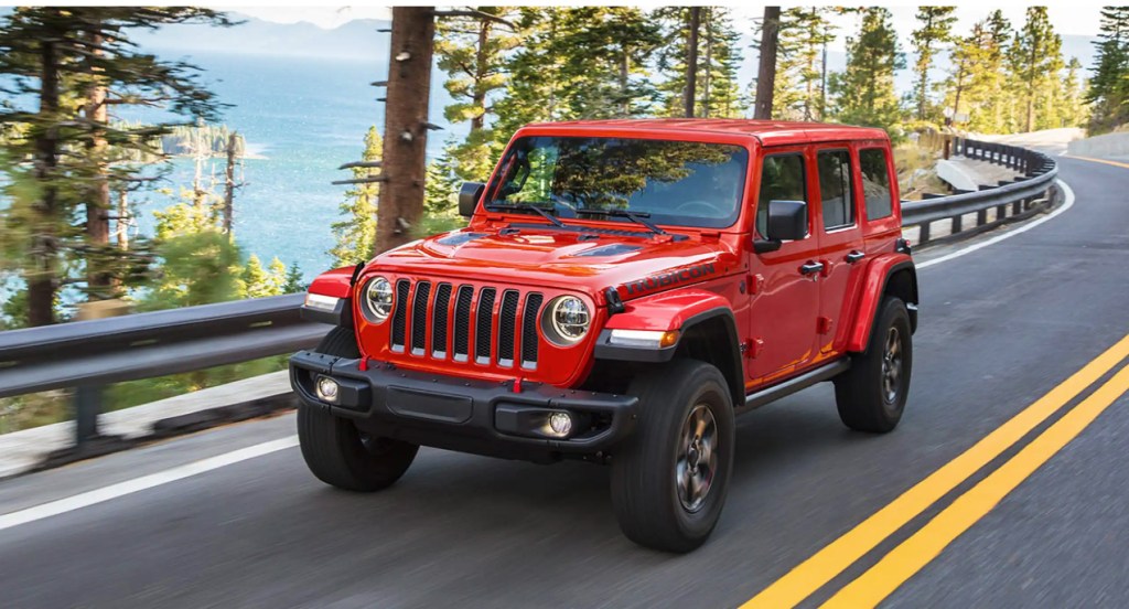 A red Jeep Wrangler is driving on the highway.