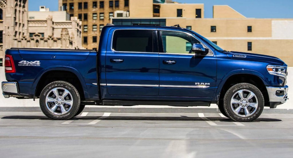 A blue Ram 1500 pickup truck is parked in a parking lot. 