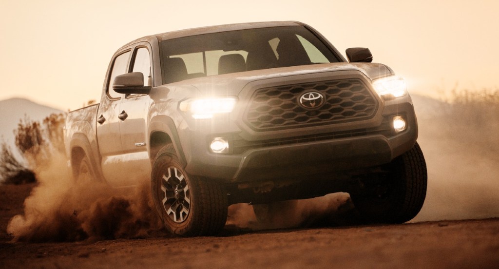 A gray Toyota Tacoma is off-roading in the dirt. 