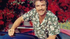Tom Selleck sits in a red Ferrari 308 for the CBS TV series 'Magnum, P.I.' in January 1984