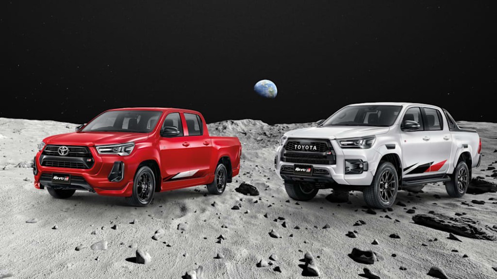 Red an silver toyota hilux trucks parked on the moon