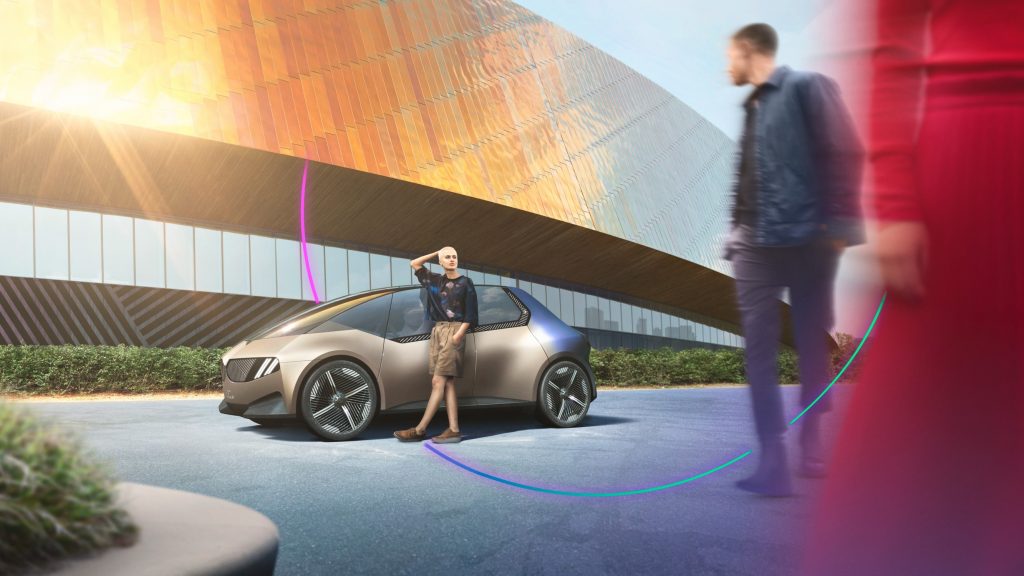 Two people standing near a beige BMW i Vision Circular Concept