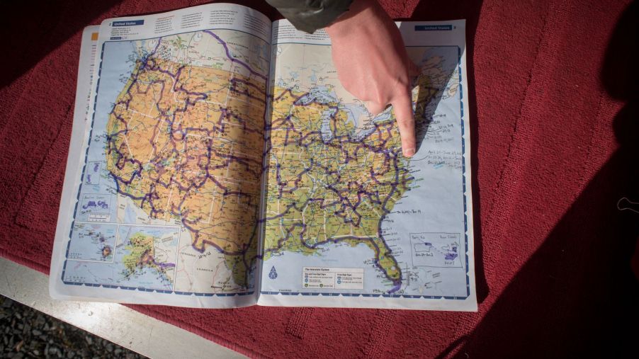 Someone pointing to a location on a map of the United States