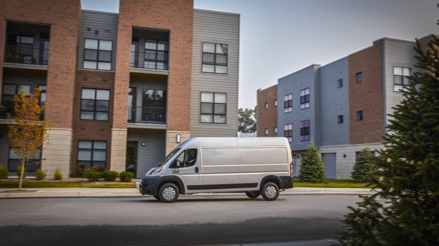 White 2022 Ram ProMaster driving by apartment buildings