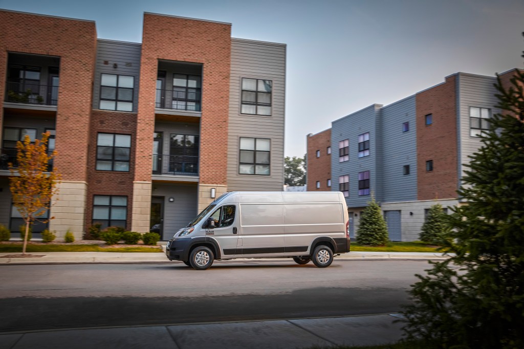 White 2022 Ram ProMaster driving by apartment buildings