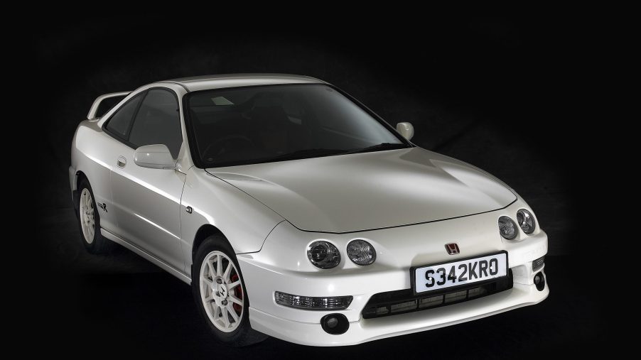 A white Acura Integra Type R shot from the front 3/4 in a black studio