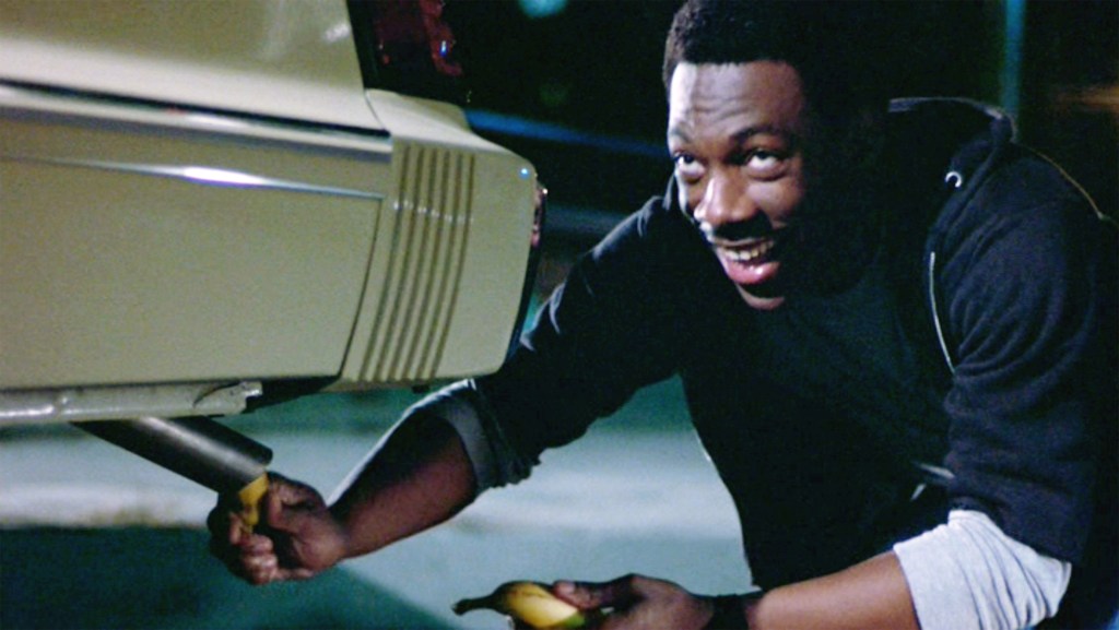 The movie "Beverly Hills Cop", directed by Martin Brest. Seen here, Eddie Murphy as Det. Axel Foley sticking a banana into the tailpipe of a 1983 Mercury Marquis sedan
