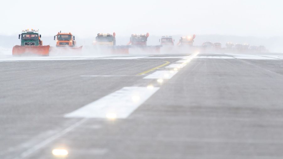 The Munich Airport covered in black ice as snow ploughs clear the runway