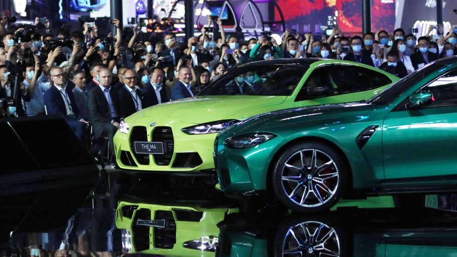 A pair of BMW M3 and M4 sports cars sporting the iconic BMW kidney grille at their debut in China, shot from the front 1/4 angle
