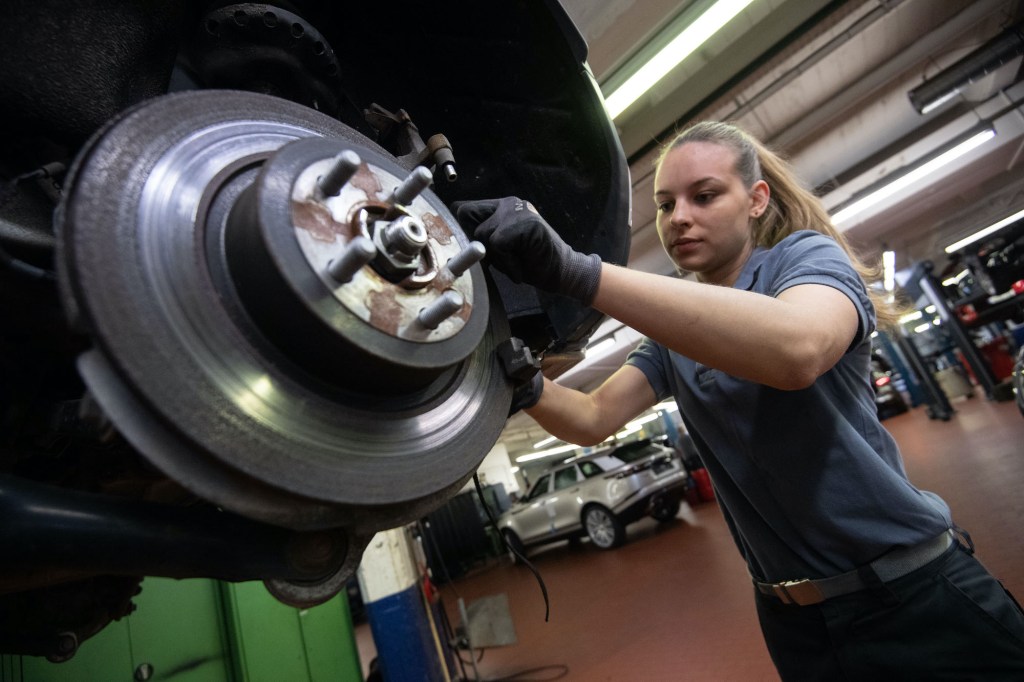 a Car mechanic works on a car's brake system