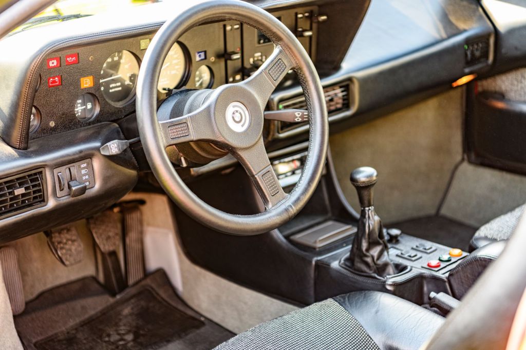 The interior of a BMW M1 with a manual transmission