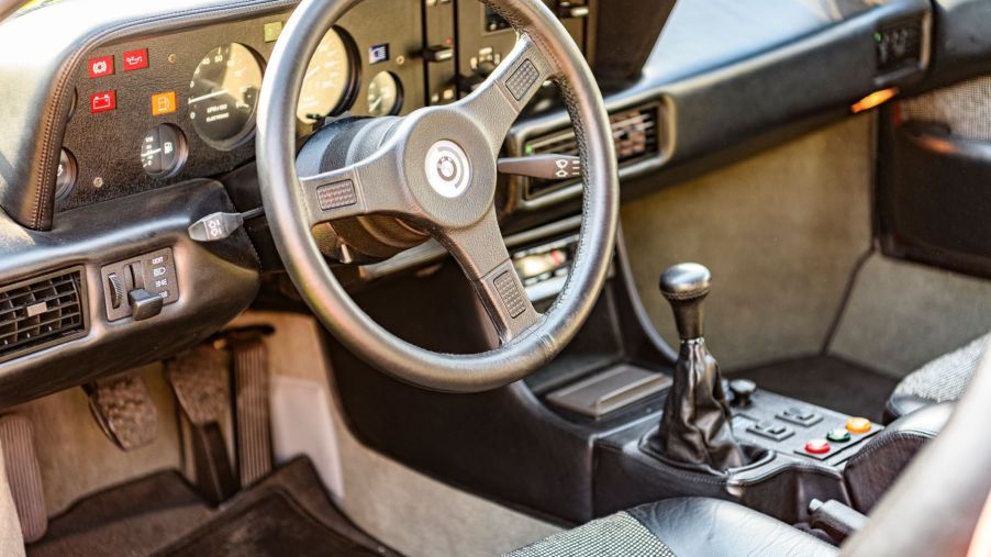 The interior of a BMW M1 with a manual transmission