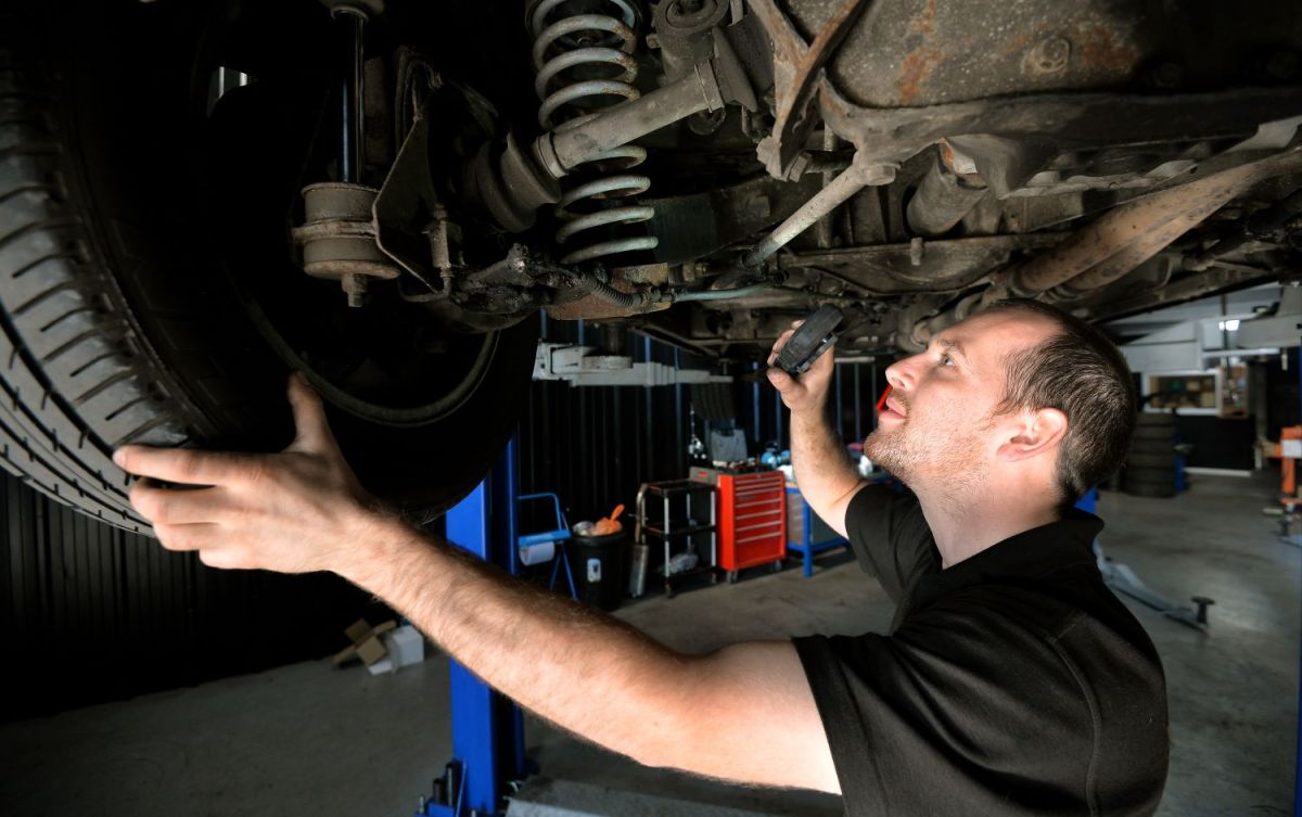 A mechanic checks a car's suspension