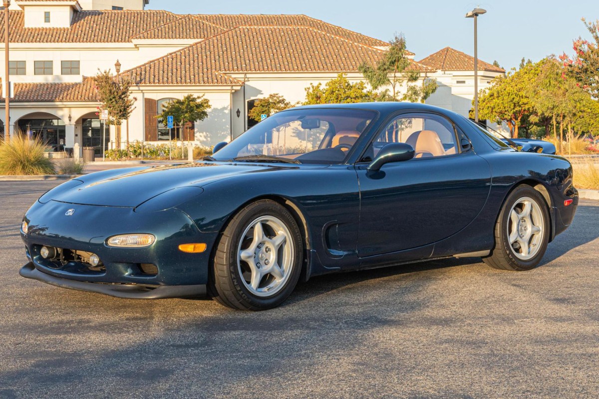 1993 Forrest Green Mazda RX-7 facing towards the left of the frame with sunset lighting.