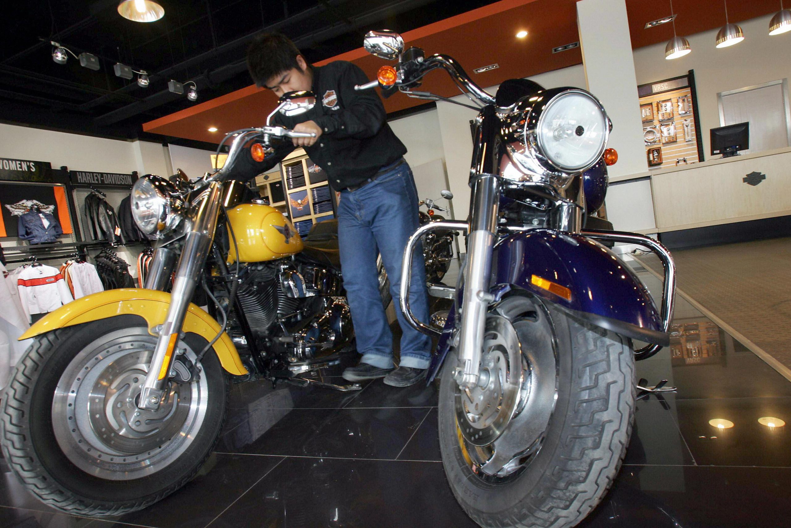  A salesman arranges one of the Harley-Davidson's bikes on display