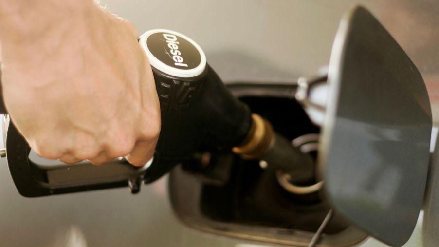A driver filling up a car at a diesel fuel station