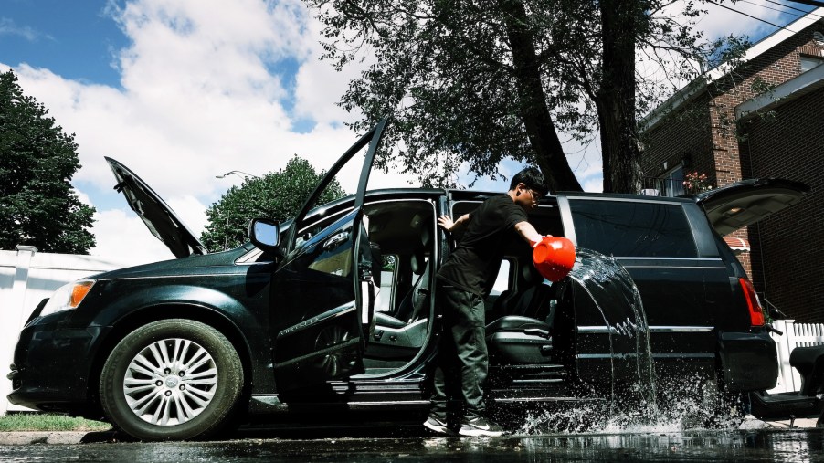 A teen cleans a flooded-damaged car in New York City after Hurricane Ida