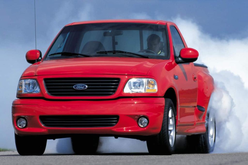 A red Ford Lightning does a burnout