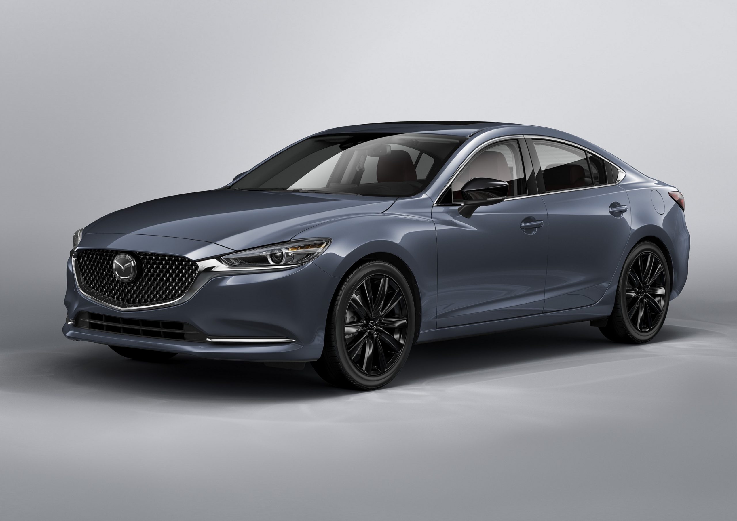 A grey 2021 Mazda 6 sedan shot from the front 3/4 angle in a studio