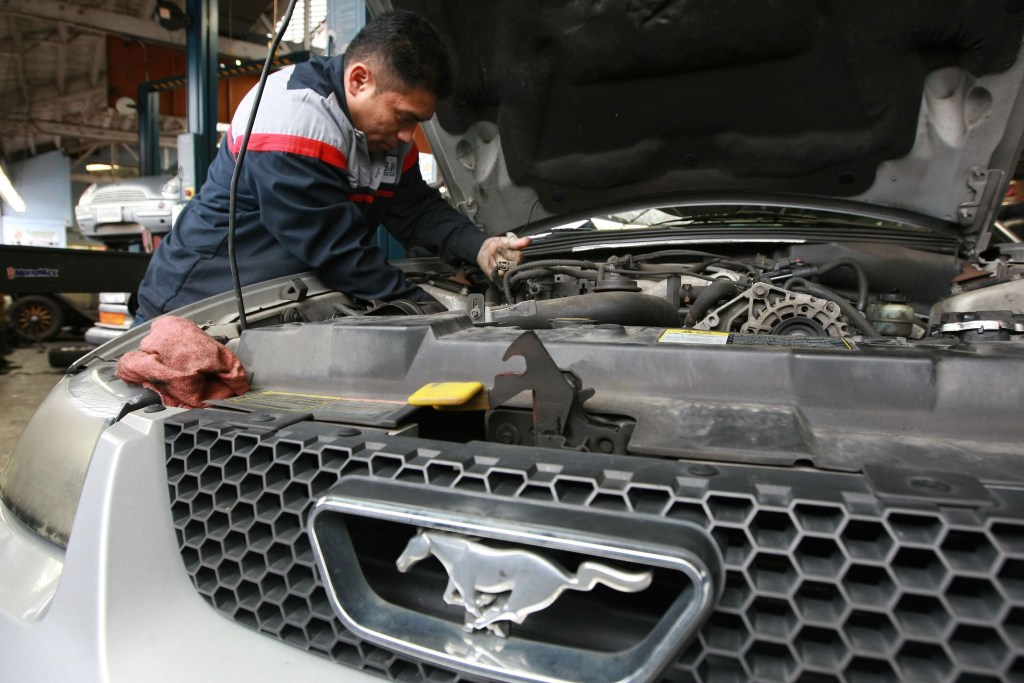 Mechanic Harrison Garcia works on a Ford Mustang at Brake and Wheel Service Center in San Francisco, California. 