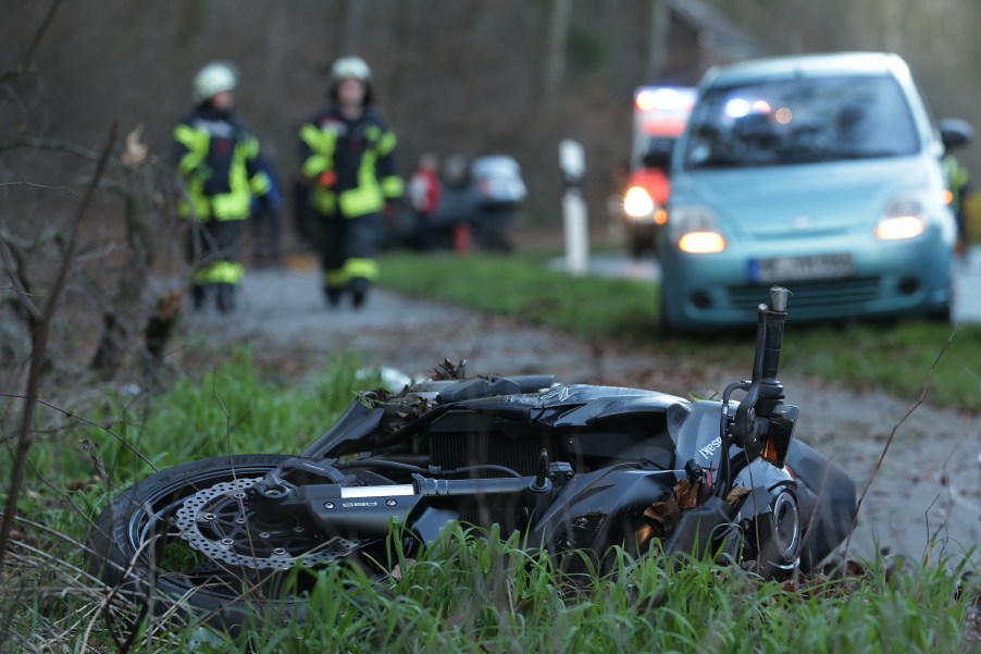A crashed motorcycle on the side of the road