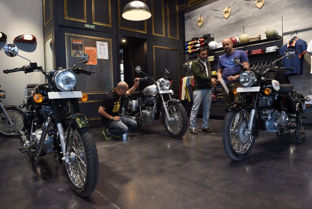 In this photograph taken on February 13, 2015, Indian customers and salesmen look at Royal Enfield motorcycles at a showroom in New Delhi.