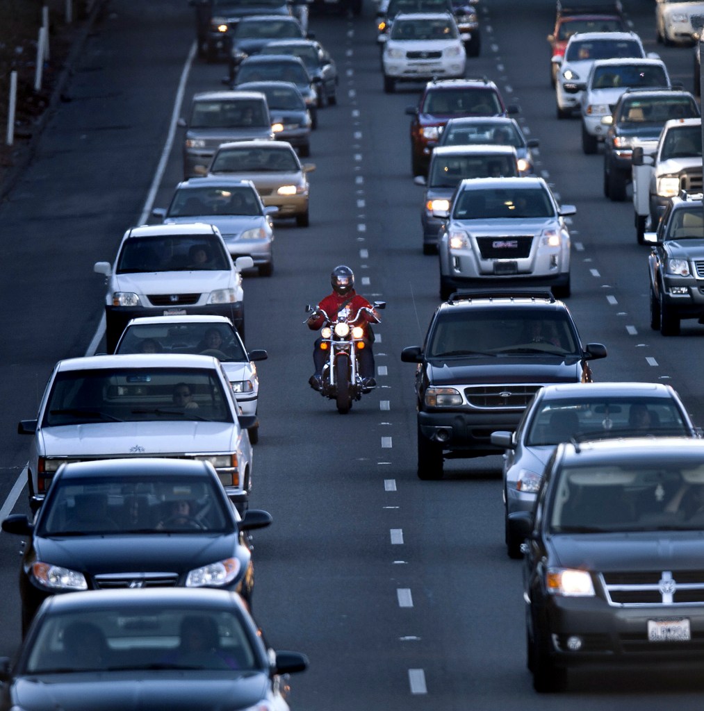 A motorcyclist rides between the lanes during the afternoon commute on southbound highway 99 
