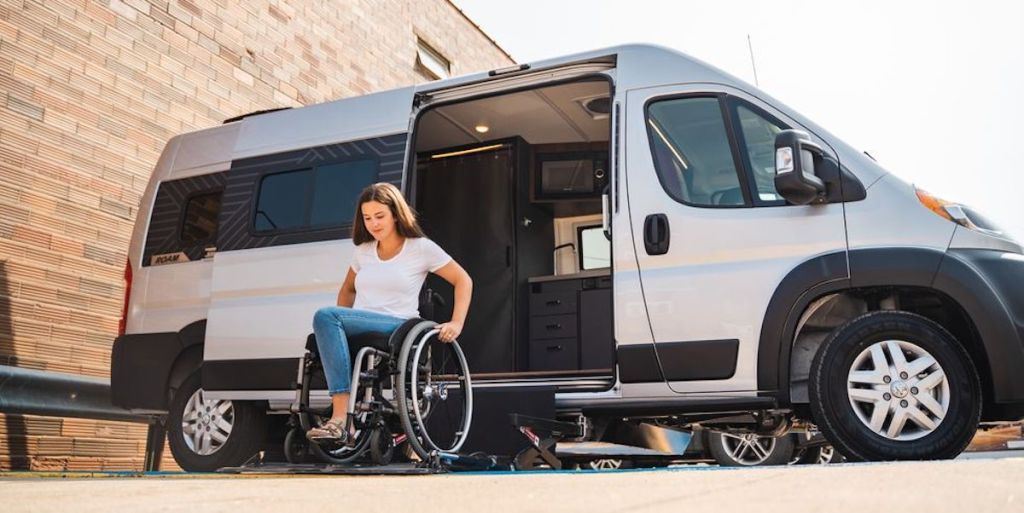 a woman using the lift in the new wheelchair accessible Winnebago Roam 