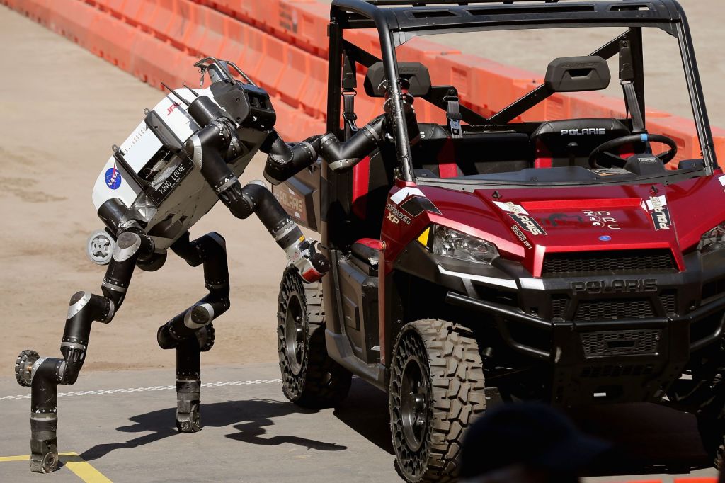 A Nasa robot entering a Polaris vehicle to drive it