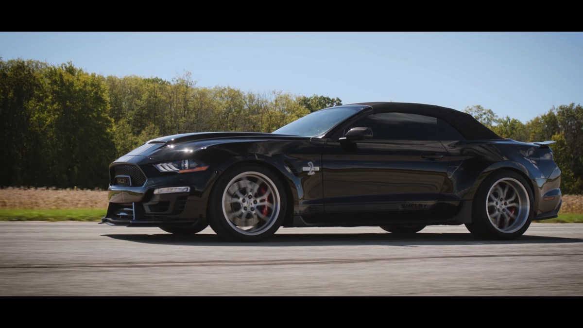 A black Shelby Super Snake Ford Mustang convertible preparing for a drag race