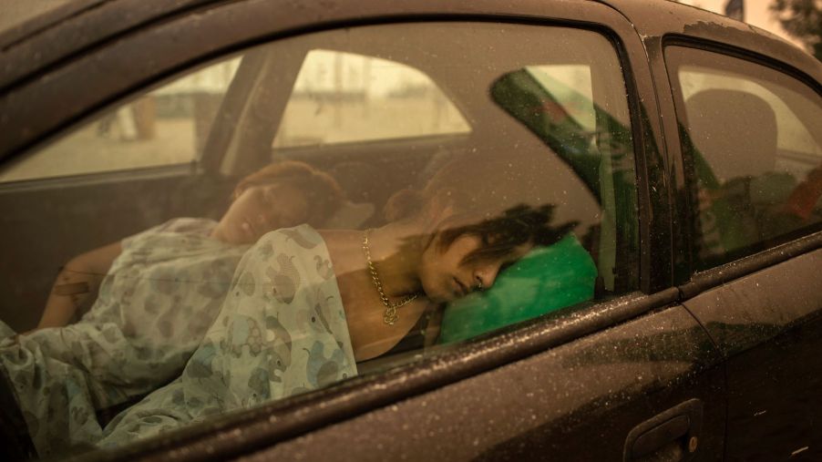 A woman and child sleeping in a car in the Pefki village of Euboea, Italy