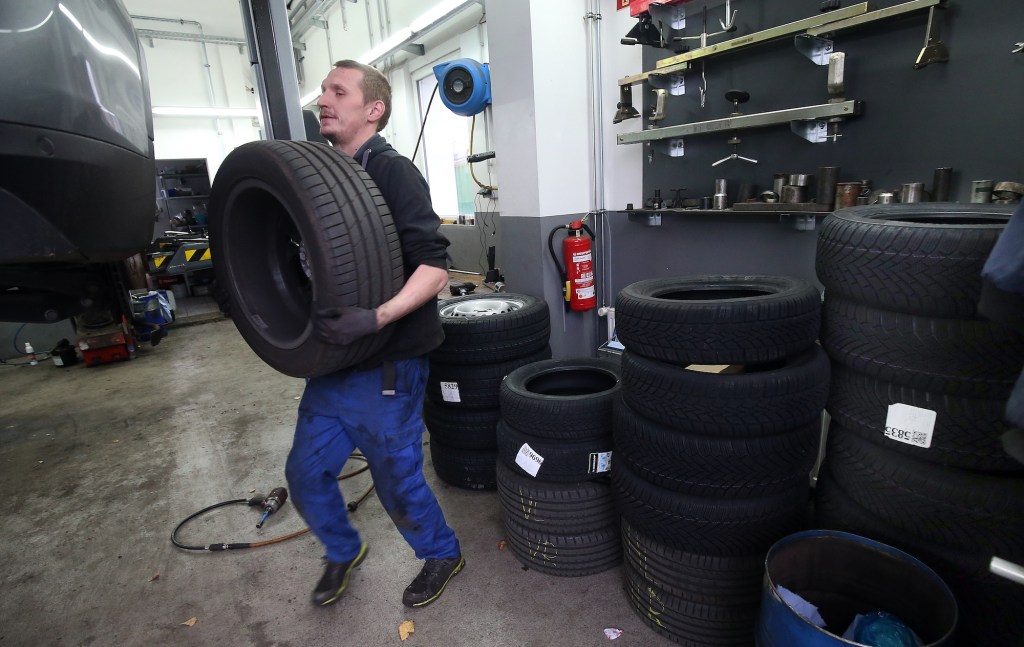 A mechanic at a car repair shop in the Lichtenberg district changes a vehicle from summer to winter tires.
