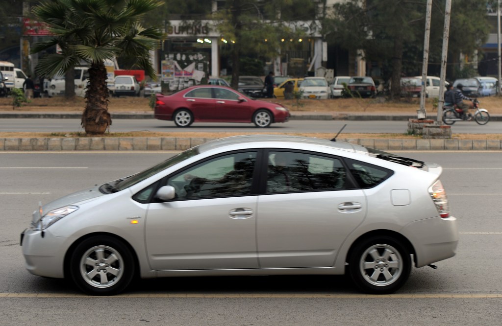 A man driving a hybrid car along the streets of Islamabad