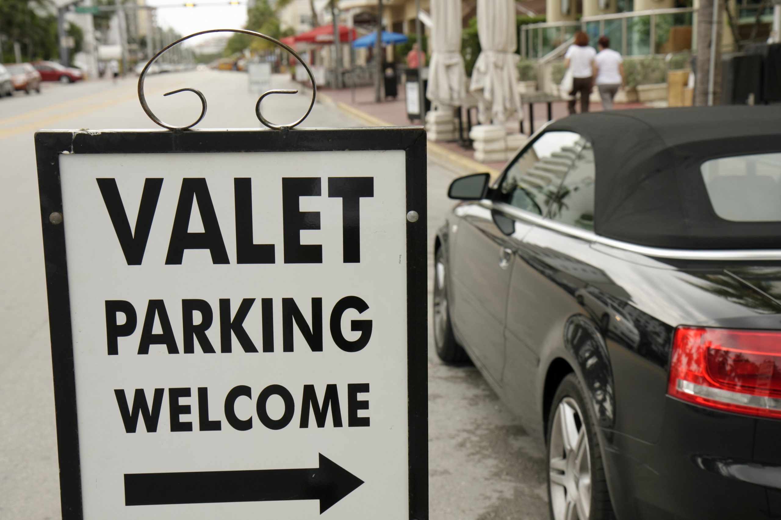A white sign that reads "Valet parking"